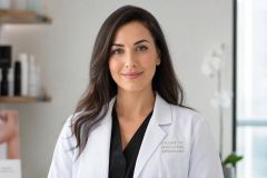 Female cosmetic medicine specialist in clinic, calm professional portrait with neutral background