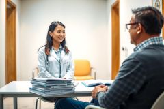 Doctor and patient in consultation. Healthcare professional discusses options with a male patient in a modern office setting. Focus on medical consultation, patient care, and professional healthcare environment.