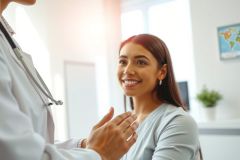Doctor examining a patient in a clinic. Healthcare professional conducts a physical exam with a stethoscope. Bright, modern medical environment. Focus on patient care and wellness.