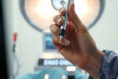Close-up of a hand holding a pen. Focus is on the pen, with blurred background. A modern and professional image.