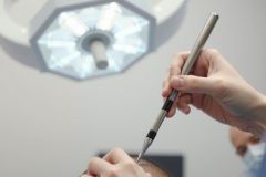Close-up of a doctor examining a patient's eye with an otoscope. Healthcare setting, bright lighting, medical examination, eye care, diagnostic tool.