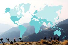 The image depicts a group of people at the top of a mountain, with a clear view of the world map. They are standing on a rocky outcrop overlooking the valley below.