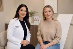Cosmetic medicine consultation with clinician and patient seated in a calm, neutral clinic setting.