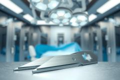 Surgical instruments on a blue draped operating table. Focus on stainless steel tools in a clean, sterile medical environment. The scene highlights the precision and focus of a surgical procedure.
