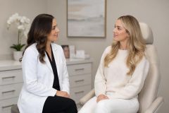 Doctor and patient in clinic consultation discussing cosmetic procedure options in calm exam room.