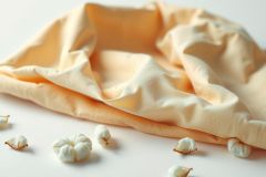 Close-up of textured cotton fabric with cotton pods scattered on a white surface. Soft focus highlights the natural fibers and subtle color variations. Perfect for textile, cotton, or natural beauty themes.